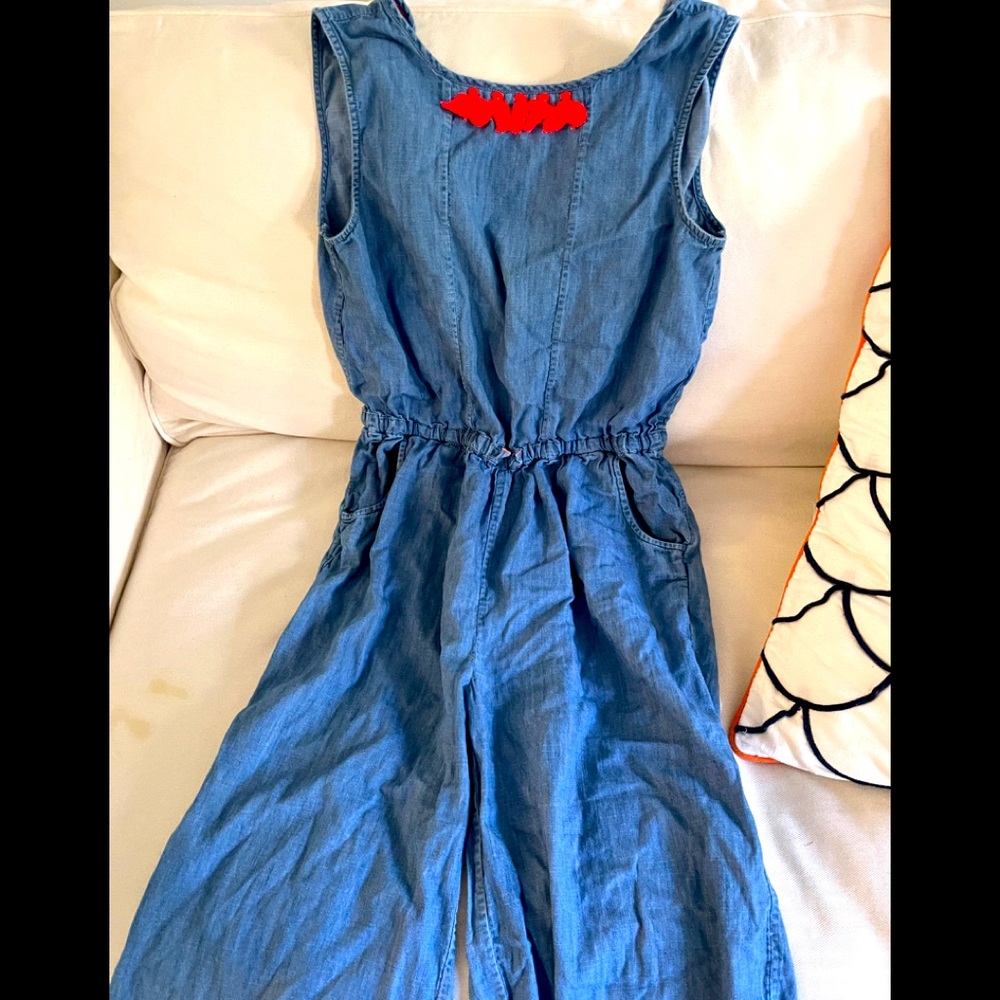 Denim jumpsuit with orange/pink tassels